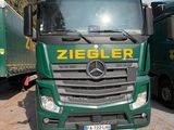 deux camions verts garés l'un à côté de l'autre sur un parking
