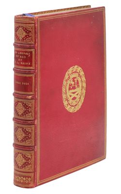 un vieux livre rouge avec un emblème doré sur la couverture