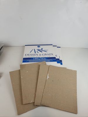 trois morceaux de carton posés sur une table, à côté d'une paire de ciseaux