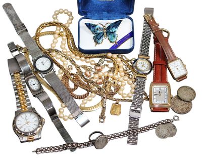 de nombreuses montres et autres bijoux posés sur une surface blanche