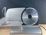 a close up of a food slicer on a wooden table