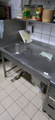 une cuisine en inox équipée d'un évier et d'un plan de travail
