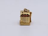 a close up of a gold charm with a ticket on it