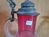 a pink glass pitcher with a bird on top of it