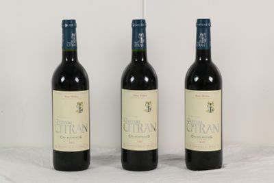 trois bouteilles de vin sont alignées sur une table