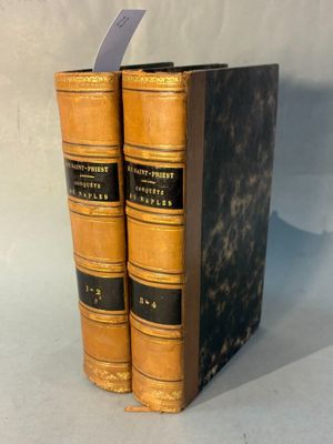 two old books sitting on top of each other on a table