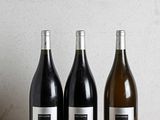 trois bouteilles de vin posées sur une table en bois