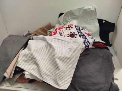 a pile of clothes sitting on top of a white shelf