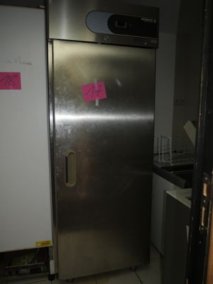 a stainless steel refrigerator in a kitchen with a pink sticker on the door