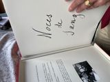 une personne tenant un livre ouvert sur lequel figurent des inscriptions