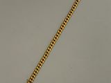 un bracelet en or sur une surface blanche