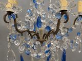 a chandelier with blue and clear crystals hanging from it