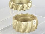 two gold rings sitting on a clear display case