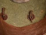 a green hat with a brown leather band and a button