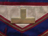 a close up of a cross on a blue and red apron
