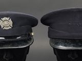 pair of black military hats with a silver emblem on them