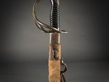 a close up of a sword with a wooden handle on a black background