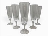 four clear wine glasses sitting on top of each other on a white surface