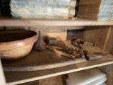 une étagère en bois sur laquelle sont posés un saladier en bois et d'autres objets