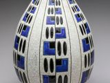 un vase blanc orné de motifs bleus et noirs