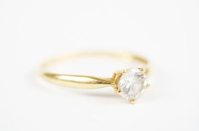 a gold ring with a white diamond on top of it