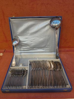silverware in a blue case on a table with a red background