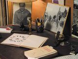 a desk with a lamp, books, and pictures on it