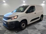 une camionnette blanche garée sur un sol en damier dans une pièce
