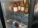 bottles of wine are sitting in a refrigerator on a shelf