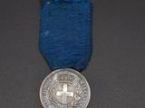 an old medal with a cross on it sitting on a table