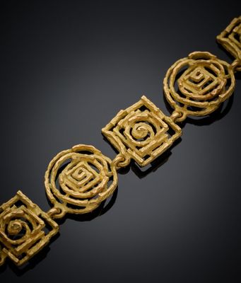un bracelet en or orné de quatre motifs en spirale sur fond noir