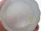 someone is holding a plastic cup in their hand that has a hole in it