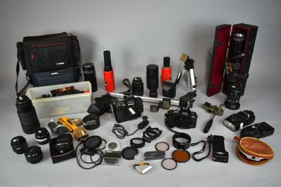 many different types of cameras and accessories laid out on the table