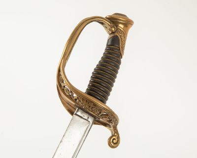 une image d'une épée avec un manche en or sur un fond blanc
