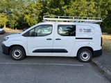 a white van parked in a parking lot with trees in the background