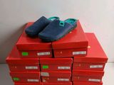 une pile de boîtes rouges sur lesquelles sont posées des chaussures bleues