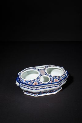 blue and white porcelain bowl with two compartments on a black surface