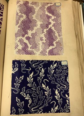 an open book with purple and white designs on it