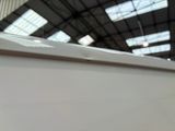 underside of a white boat in a large building with a skylight