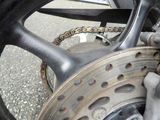 a close up of a motorcycle wheel with a chain attached to it