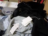 a pile of clothes and a box of clothes on the floor