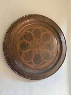 a metal plate with a design on it on the wall