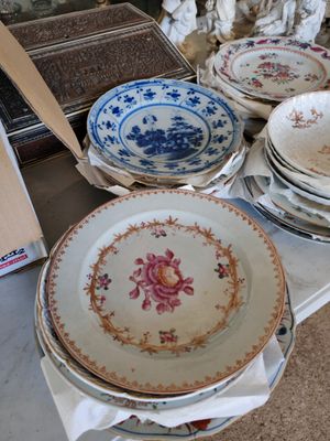 many plates and bowls on a table with a wooden spoon