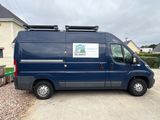 a blue van that is parked in front of a house