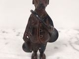 une petite figurine représentant un homme avec un chapeau et un sac