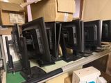 a lot of computer monitors sitting on a shelf in a room
