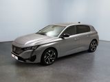 La voiture argentée est garée dans une pièce aux murs blancs.