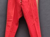 un vieux pantalon rouge accroché à un mur noir