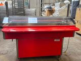 une photo d'une table rouge avec un plateau en verre dans un entrepôt