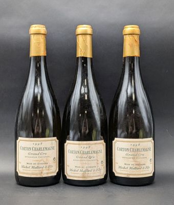 trois bouteilles de vin posées sur une table l'une à côté de l'autre